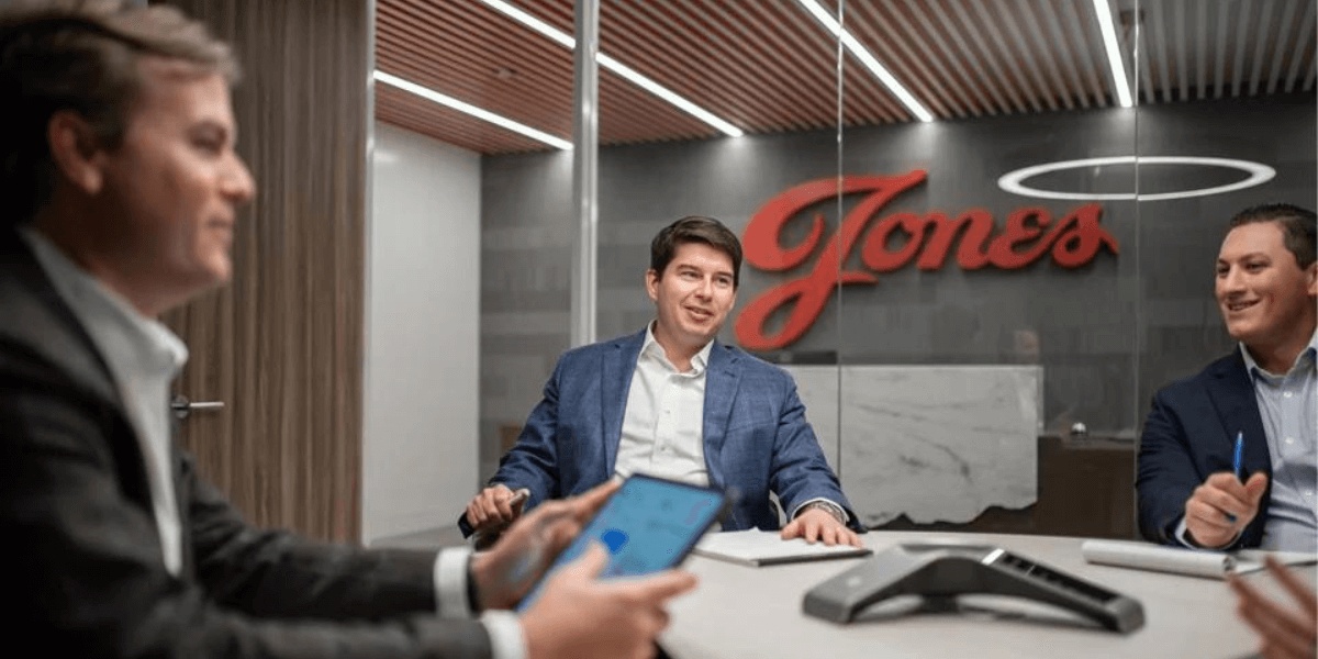 Jonathan Jones seated at a conference table with colleagues