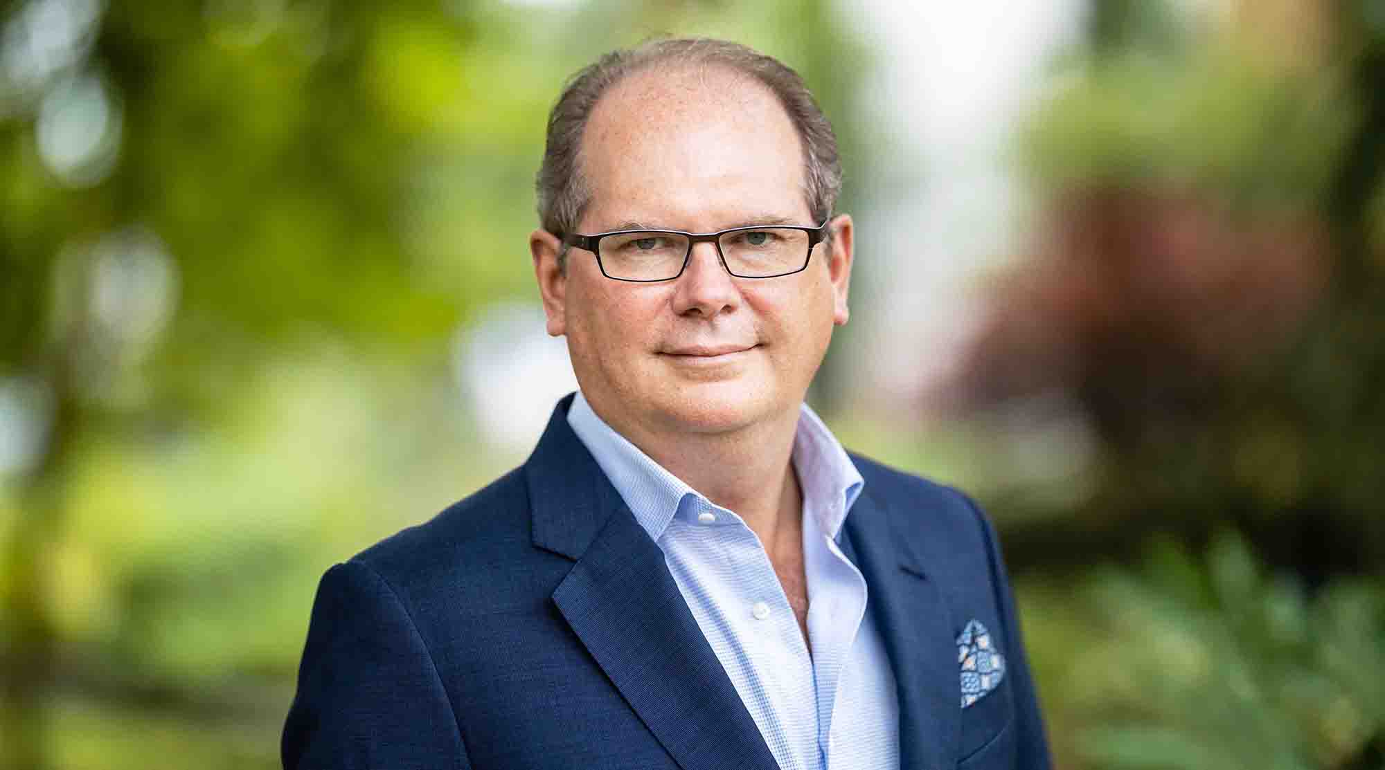 Jonathan Lakin wearing glasses and a blue jacket outdoors