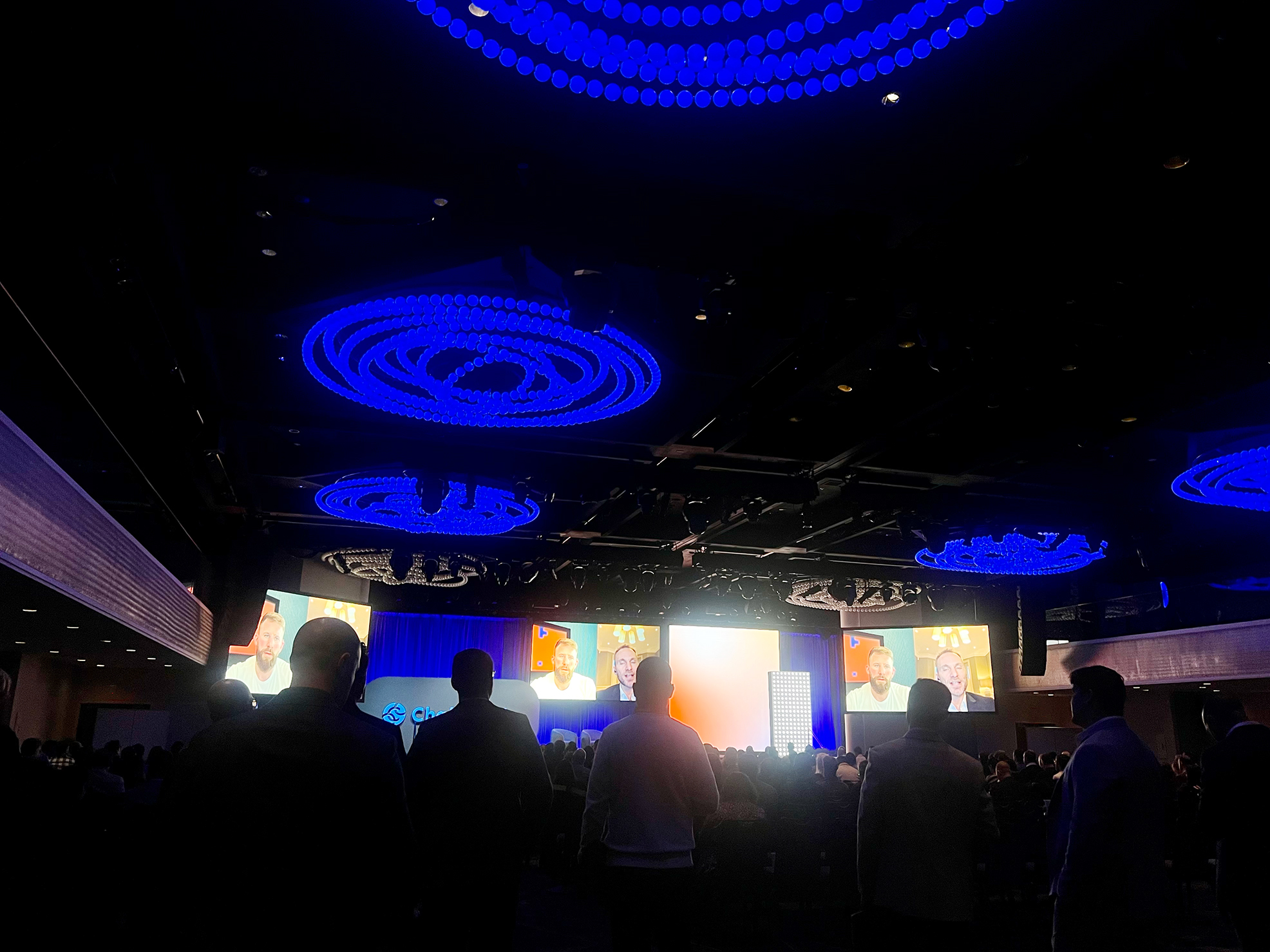 Conference audience watching Jonathan Levin and Paolo Ardoino in conversation on screens at Links NYC 2025