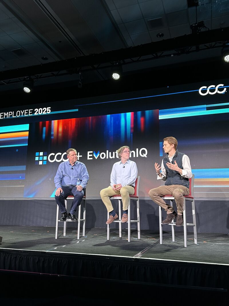 Jonathan Lewin and Mike Saltzman onstage with another participant at a CCC employee meeting in 2025