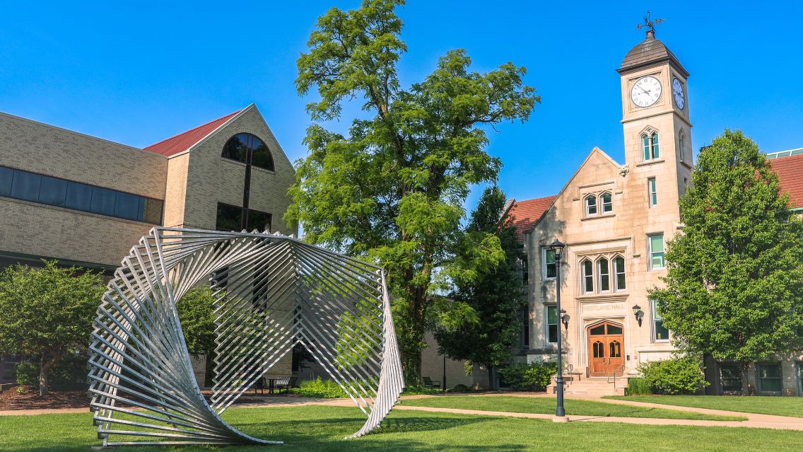 Bradley University’s campus, with Westlake Hall’s clock tower and an outdoor sculpture