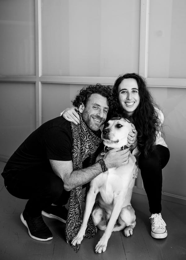 Jonathan Sabbagh and Myriam Barthes crouching beside their dog Banksy