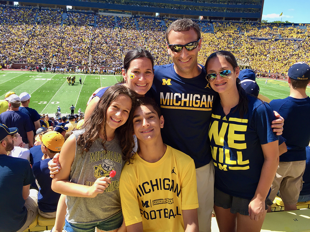 Jonathan Shar with his family in Michigan clothing at a crowded Michigan Stadium