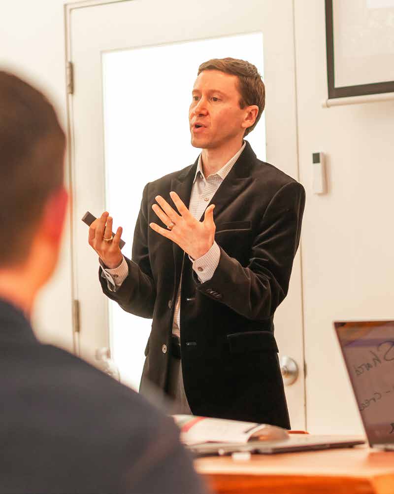 Jorey Ramer speaking and gesturing during a Super team meeting