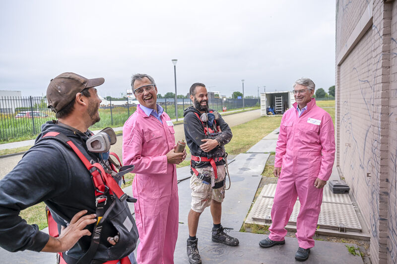 Joseph Morrissey, at right in pink overalls, with Kirke Weaver and mural artists at Organon's site in Oss