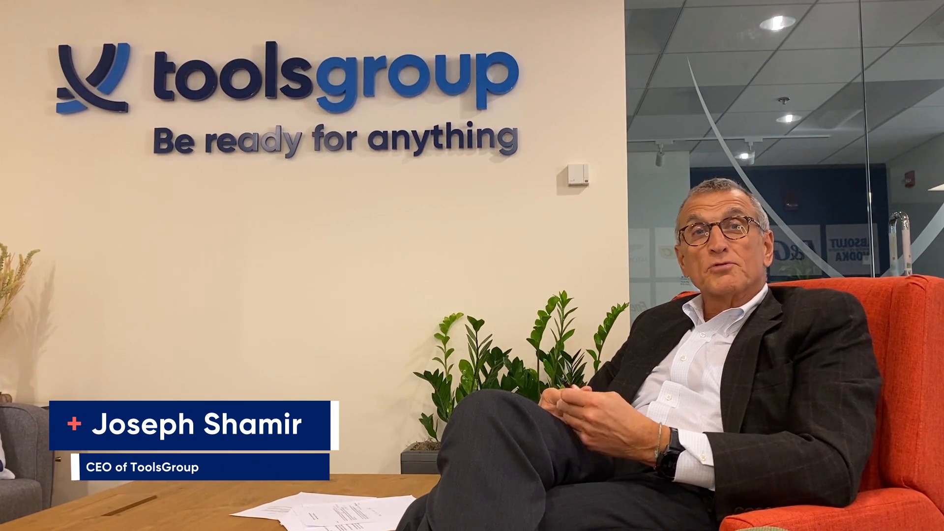 Joseph Shamir seated in a red chair at ToolsGroup’s Boston office during the November 2021 acquisition announcement