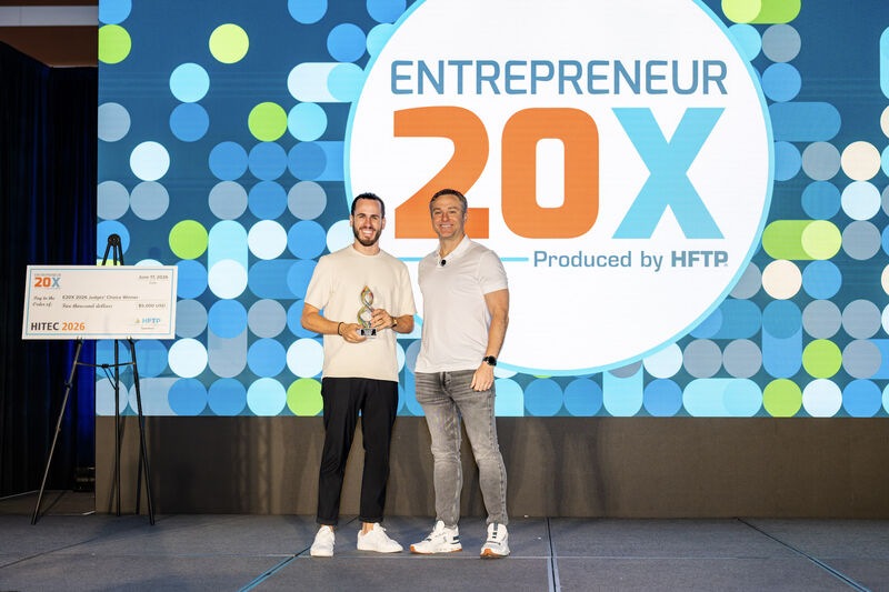 Josh Ellis holding the HITEC E20X People's Choice trophy onstage in 2026