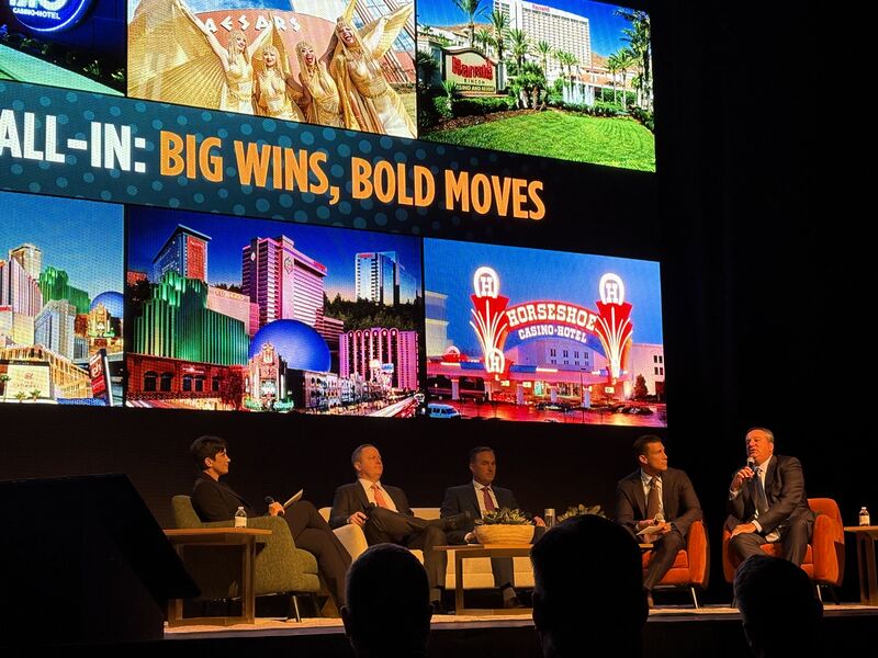 A Caesars Entertainment town-hall panel seated onstage in Reno beneath images of company destinations.