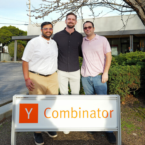 Josh Sabol standing with two HealthKey colleagues beside a Y Combinator sign