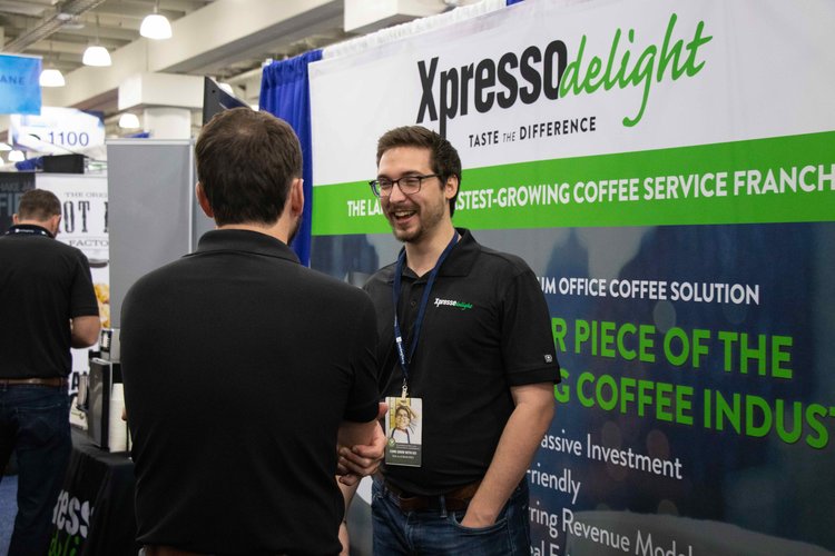 A conversation and handshake at an Xpresso Delight exhibition booth
