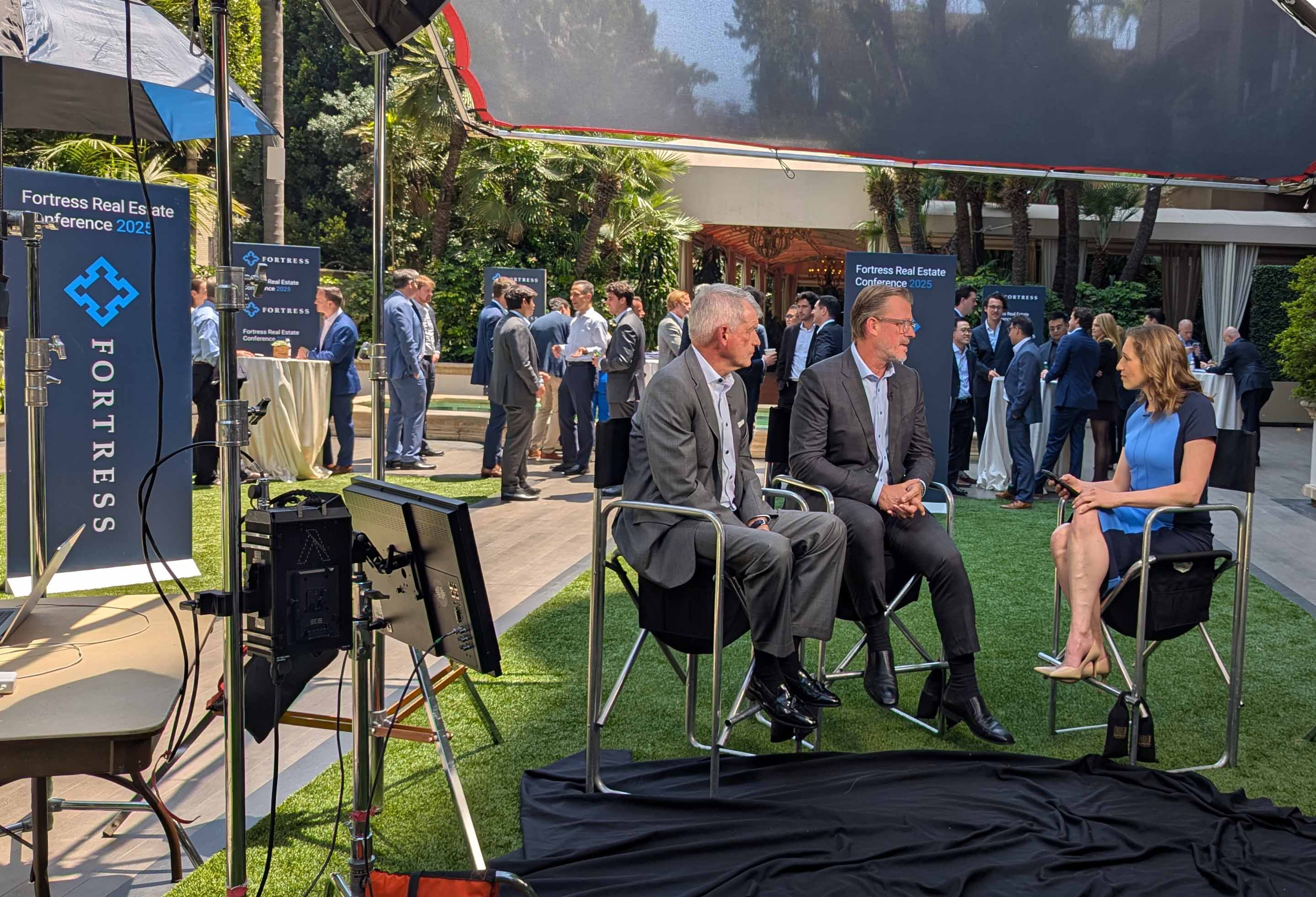 Joshua Pack and Tim Sloan speaking with Lisa Abramowicz during Fortress’s 2025 real estate conference