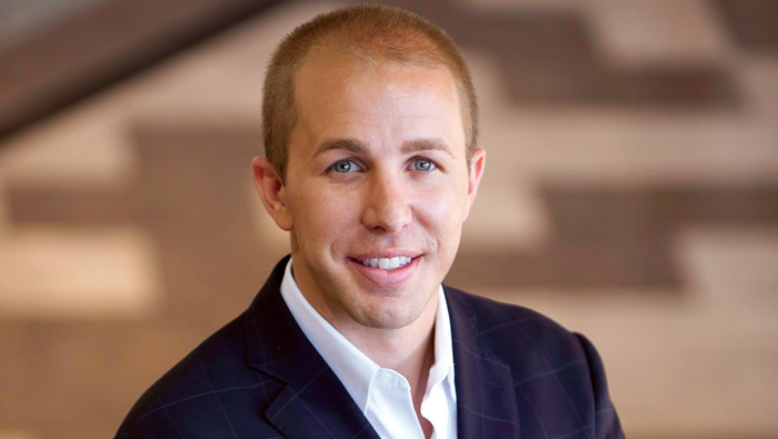 Joshua Simon seated in a SimonCRE office setting