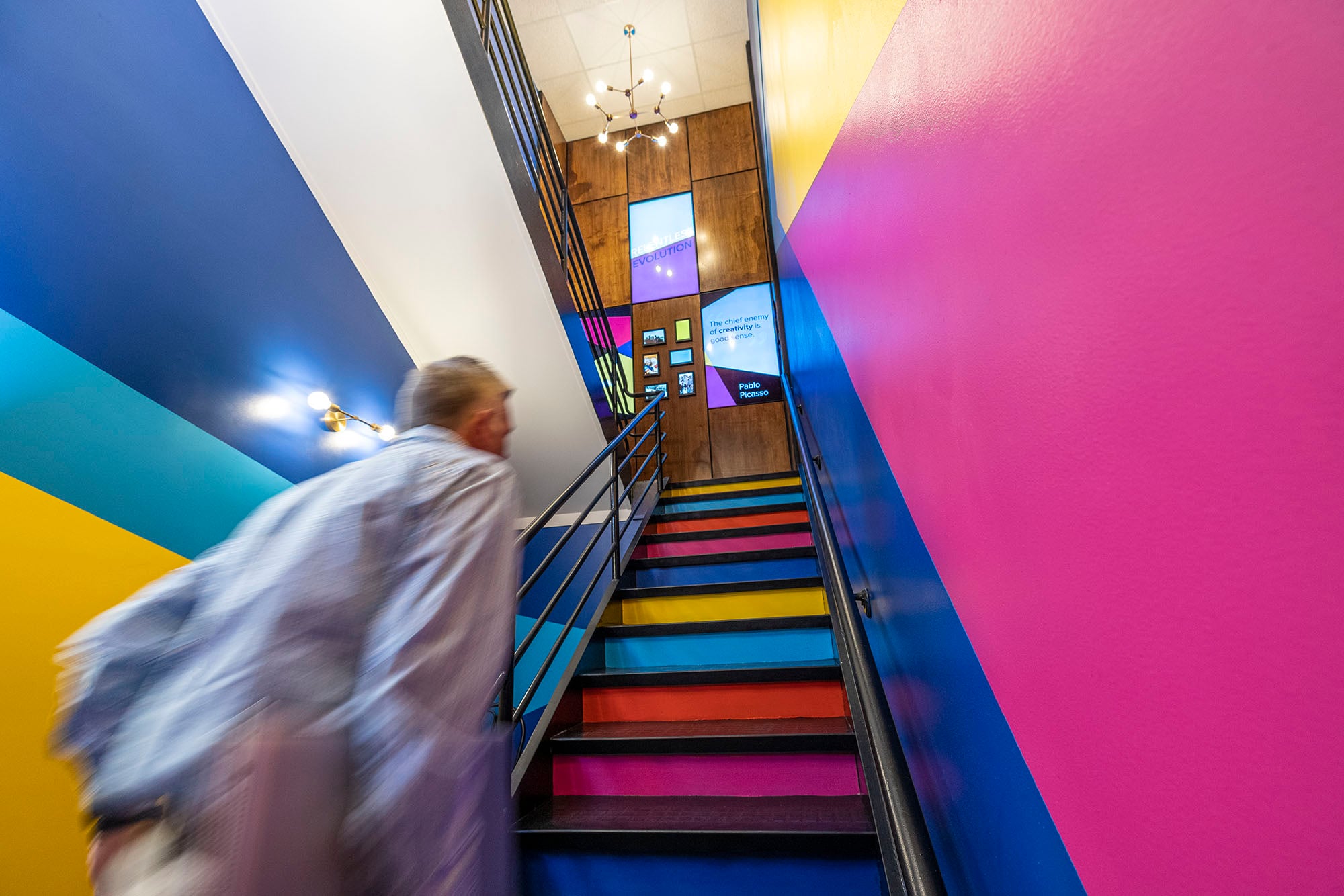 A person moving up JPL's brightly colored office staircase