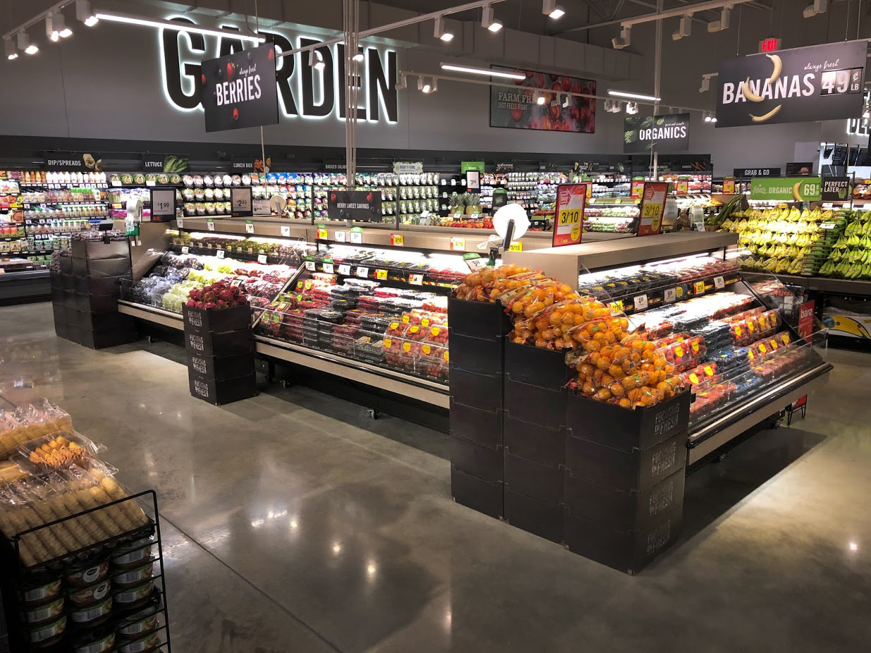 Grocery store perimeter with wooden produce and floral displays