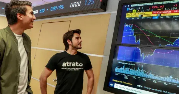 Juan Casian and an Atrato co-founder beside market data screens during Atrato's early accelerator period