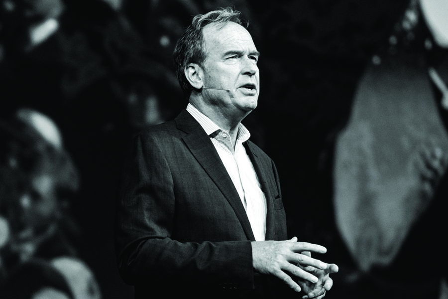 Jud Bergman speaking, with his hands together, in a black-and-white photograph