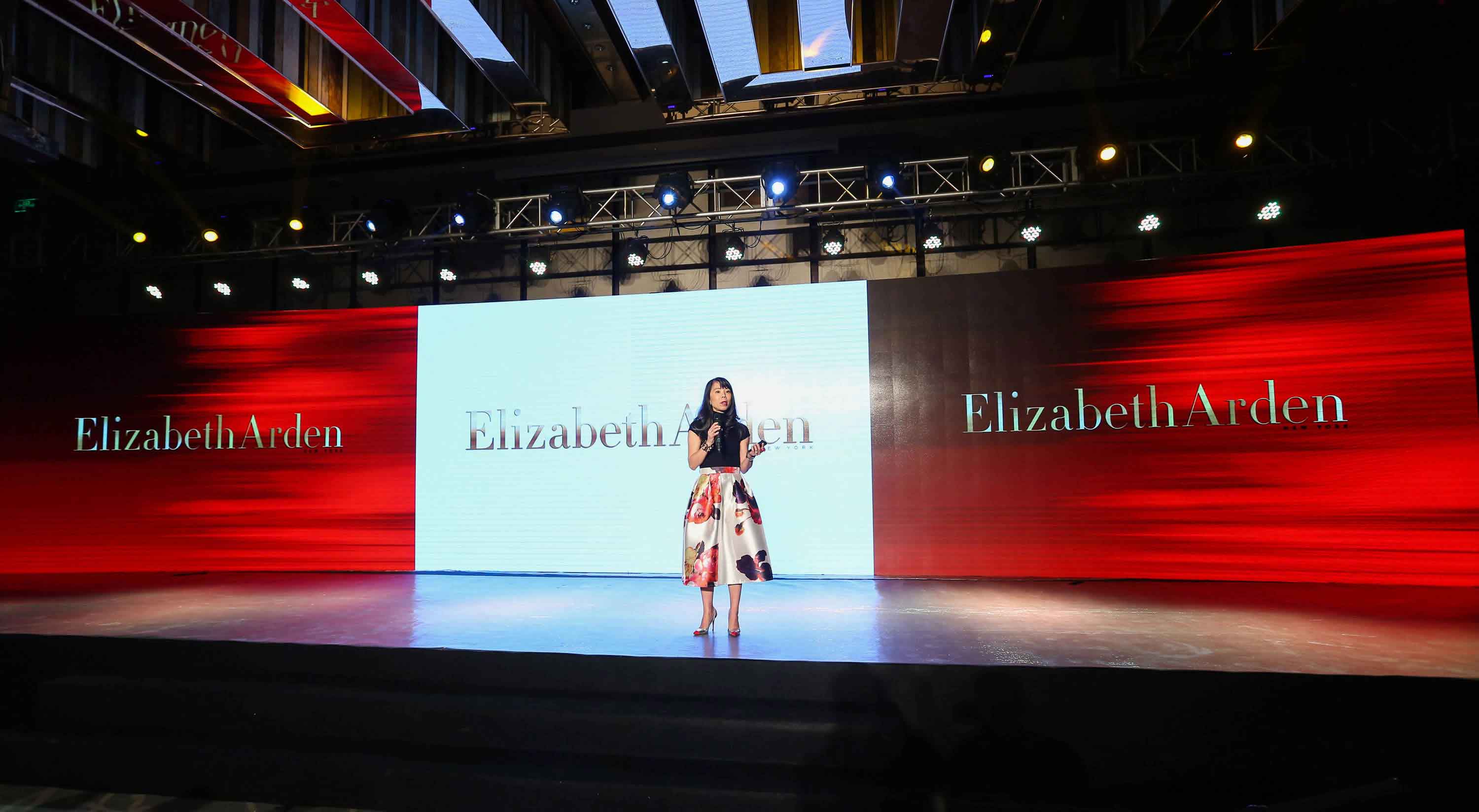 Jue Wong speaking on an Elizabeth Arden stage at an event in China