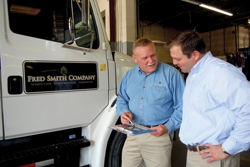 Jule Smith, right, talking with Fred Smith Company employee Jeff Storms beside a company truck