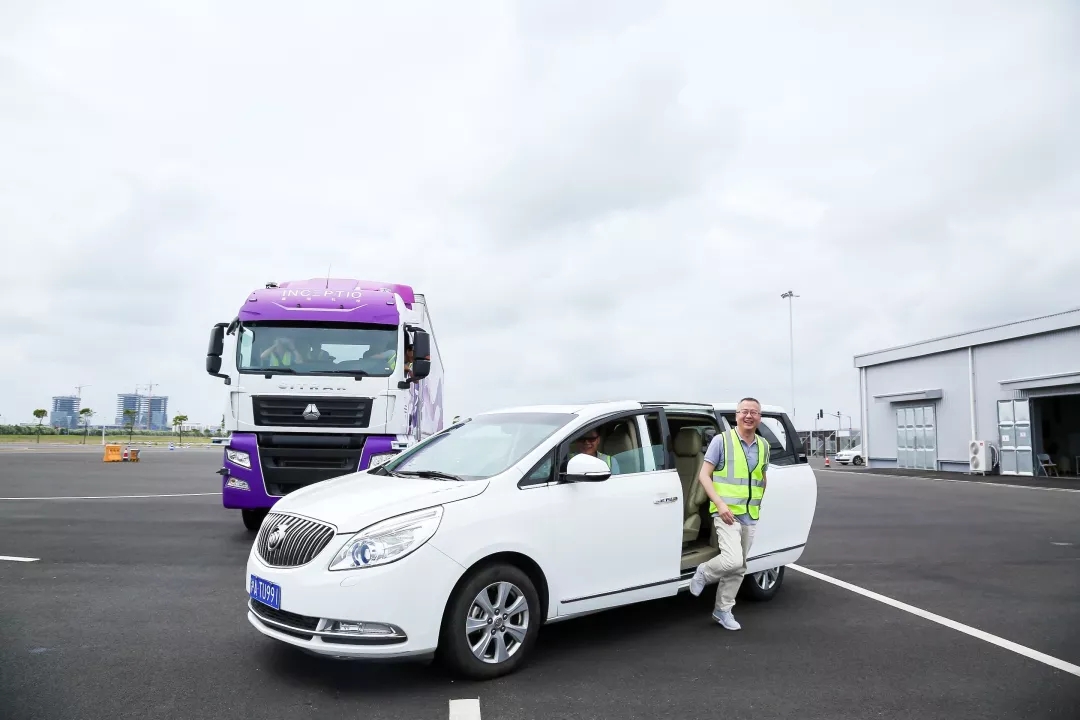 Julian Ma in a fluorescent vest beside the demonstration car with Inceptio’s truck behind it
