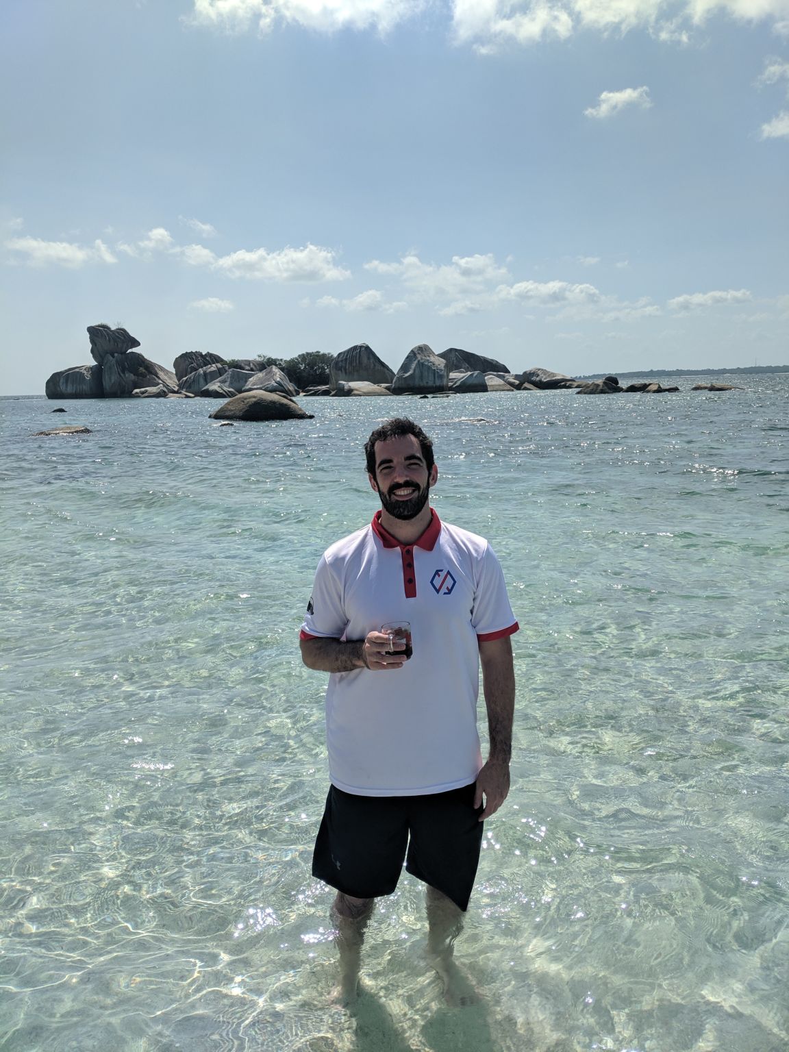 Julian Rowlands standing in shallow sea water during a Xendit retreat on Belitung island in 2019