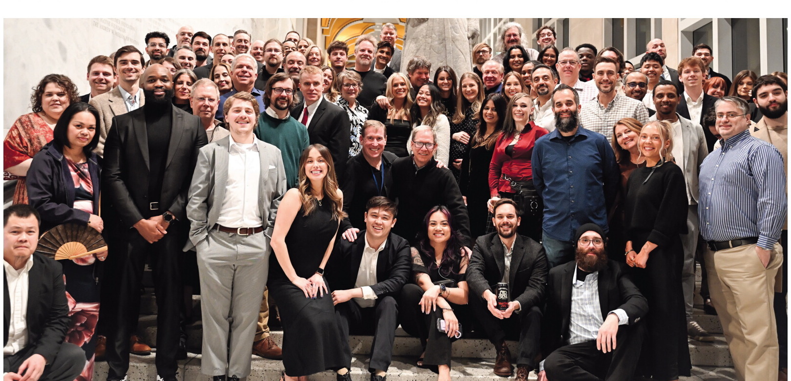 A large group of Concord Technologies employees gathered on indoor steps at a company event