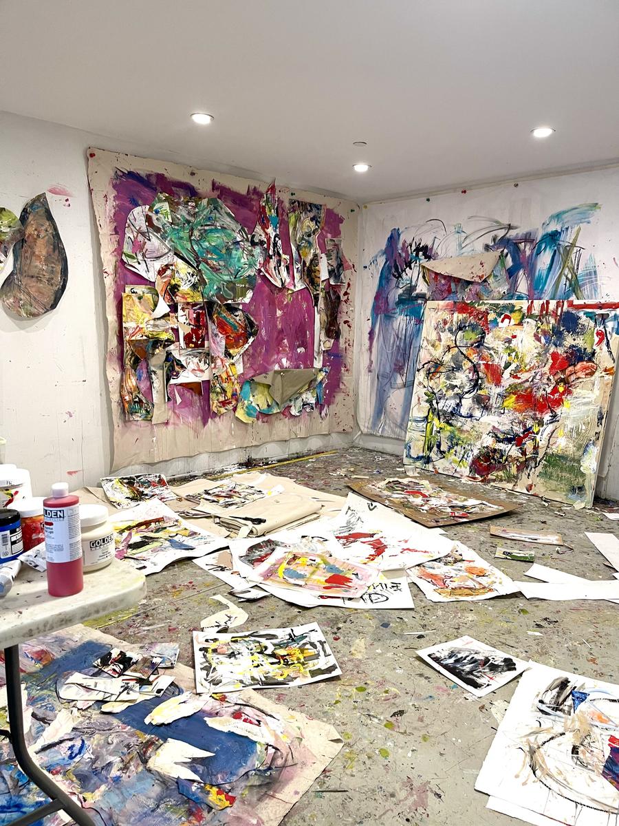 Julie Markfield’s studio, with painted papers across the floor and large colorful works on the walls