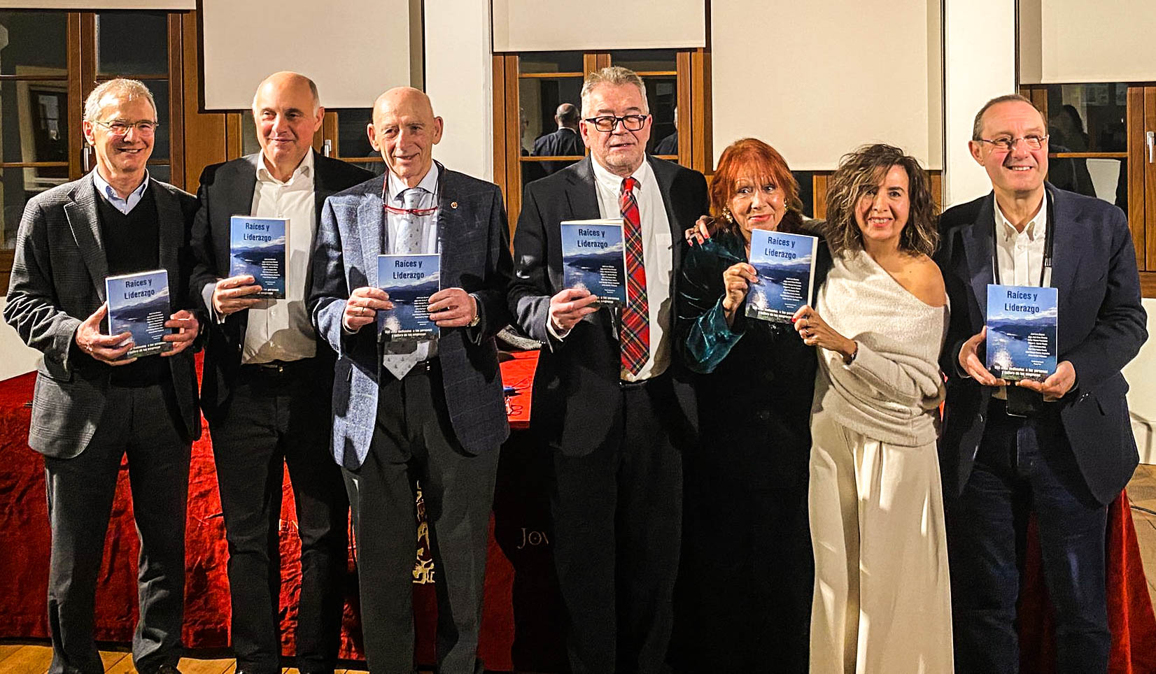 Julio Rodríguez Díaz, second from left, with fellow contributors holding copies of Raíces y liderazgo
