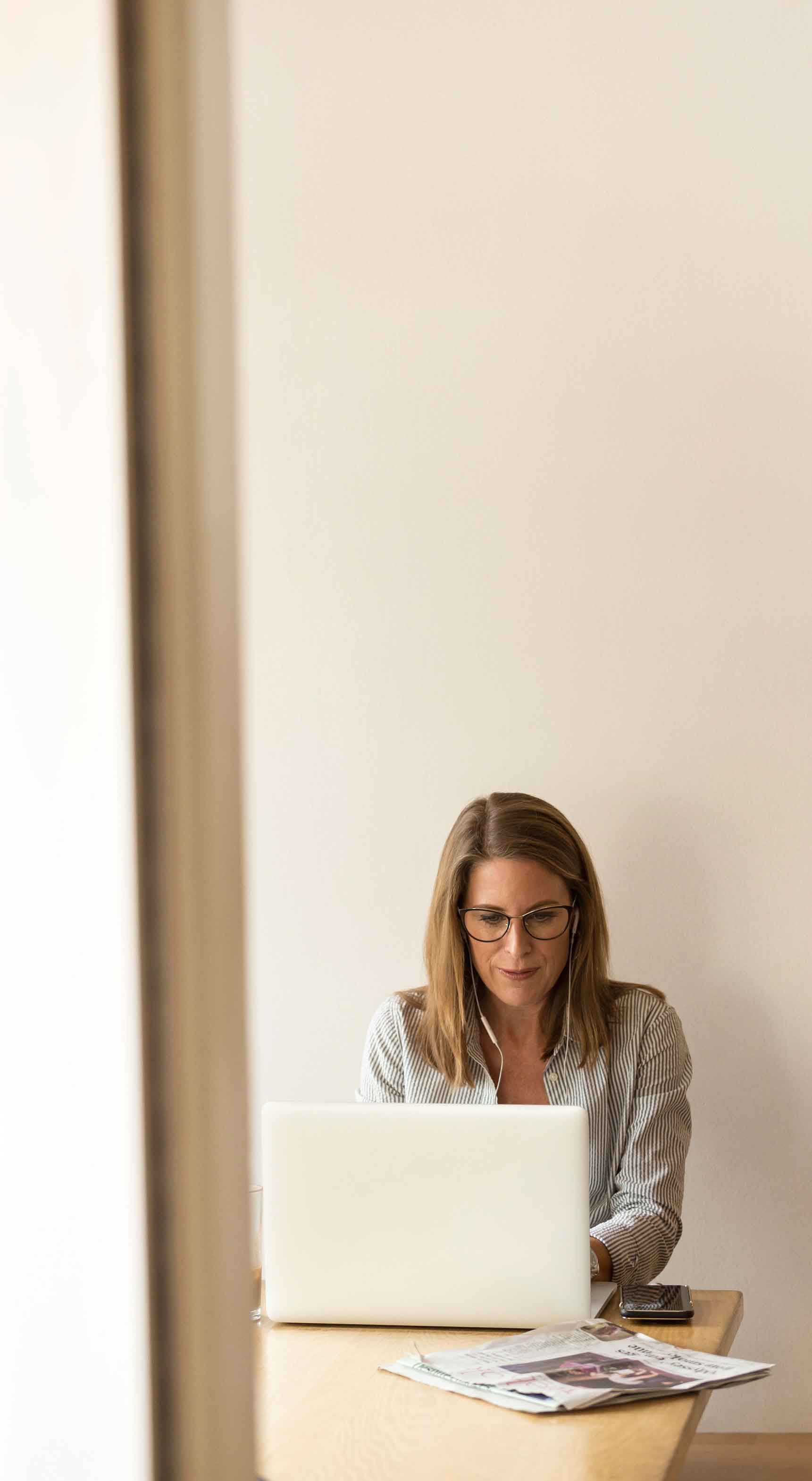 Illustrative photograph from JULIUS’s about page of a woman working at a laptop