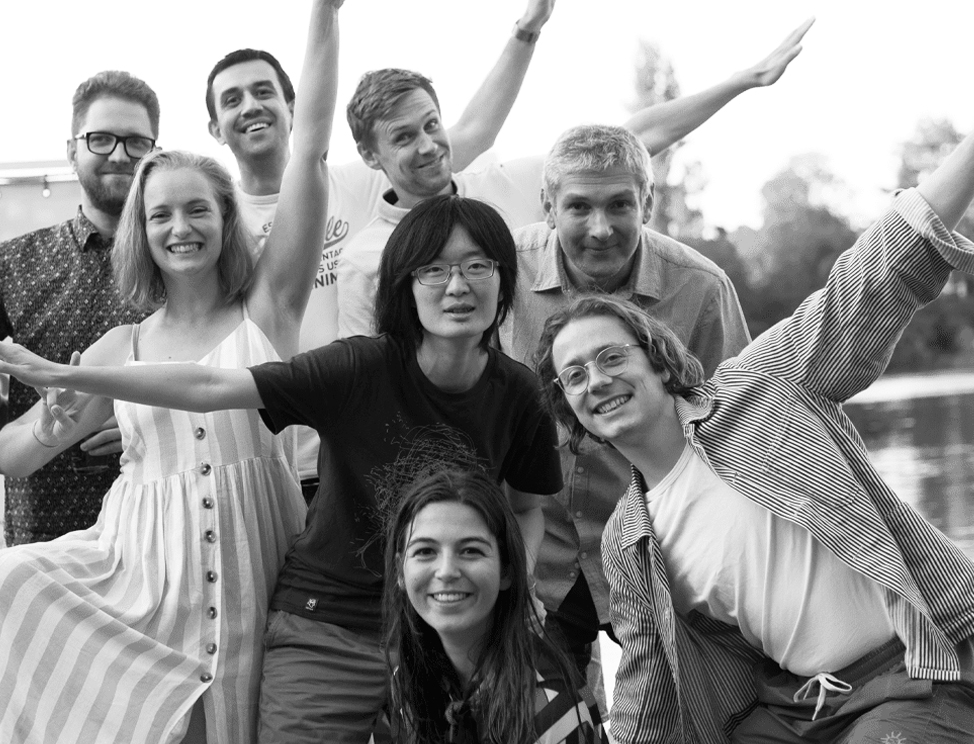 People posing with outstretched arms in a photograph from Jumio’s careers page