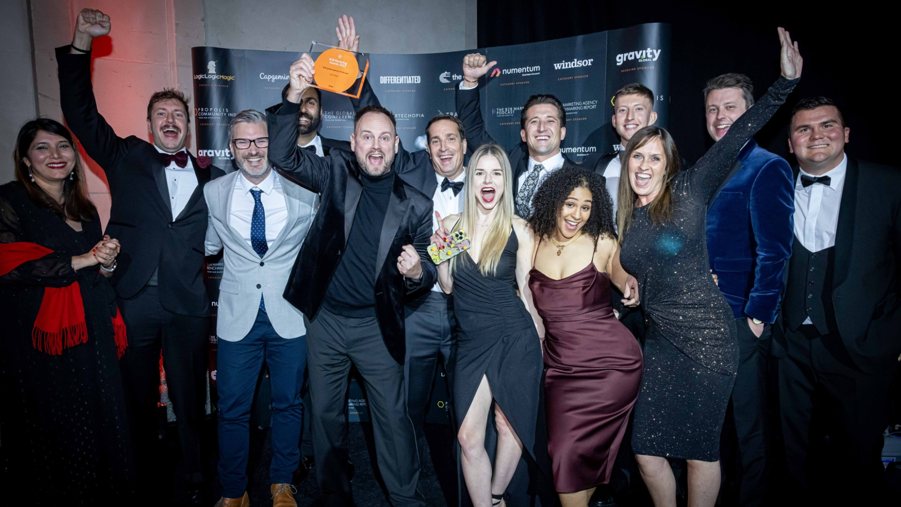 Just Global team members celebrate with their 2023 Global B2B Agency of the Year trophy