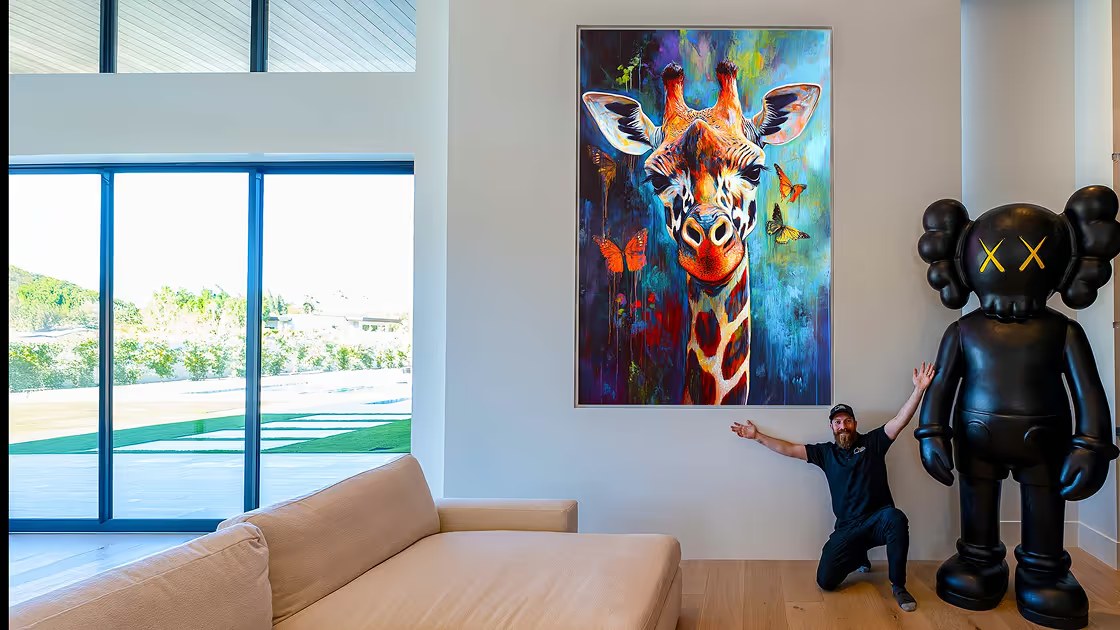 A tall portrait-orientation microLED wall displaying a giraffe in a modern home
