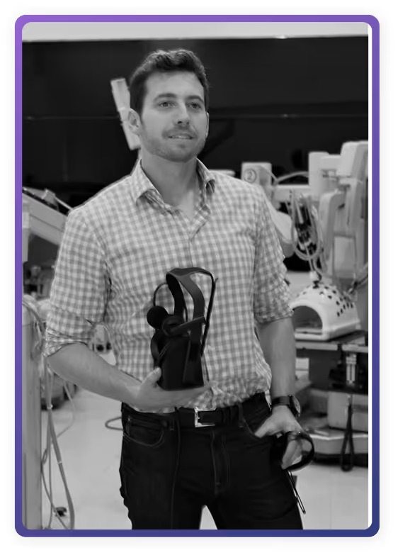 Justin Barad holding an early virtual reality headset in a clinical training space