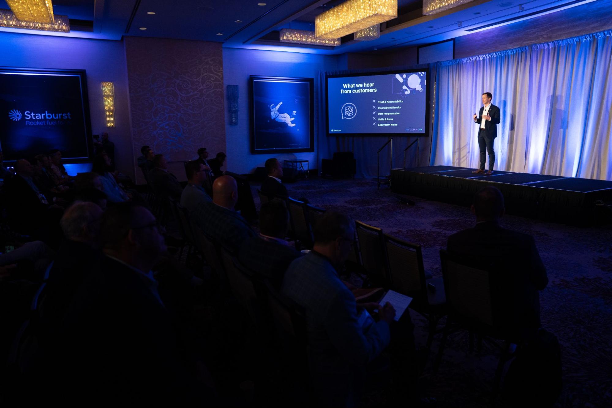 Justin Borgman on stage addressing an audience at AI and Datanova 2025