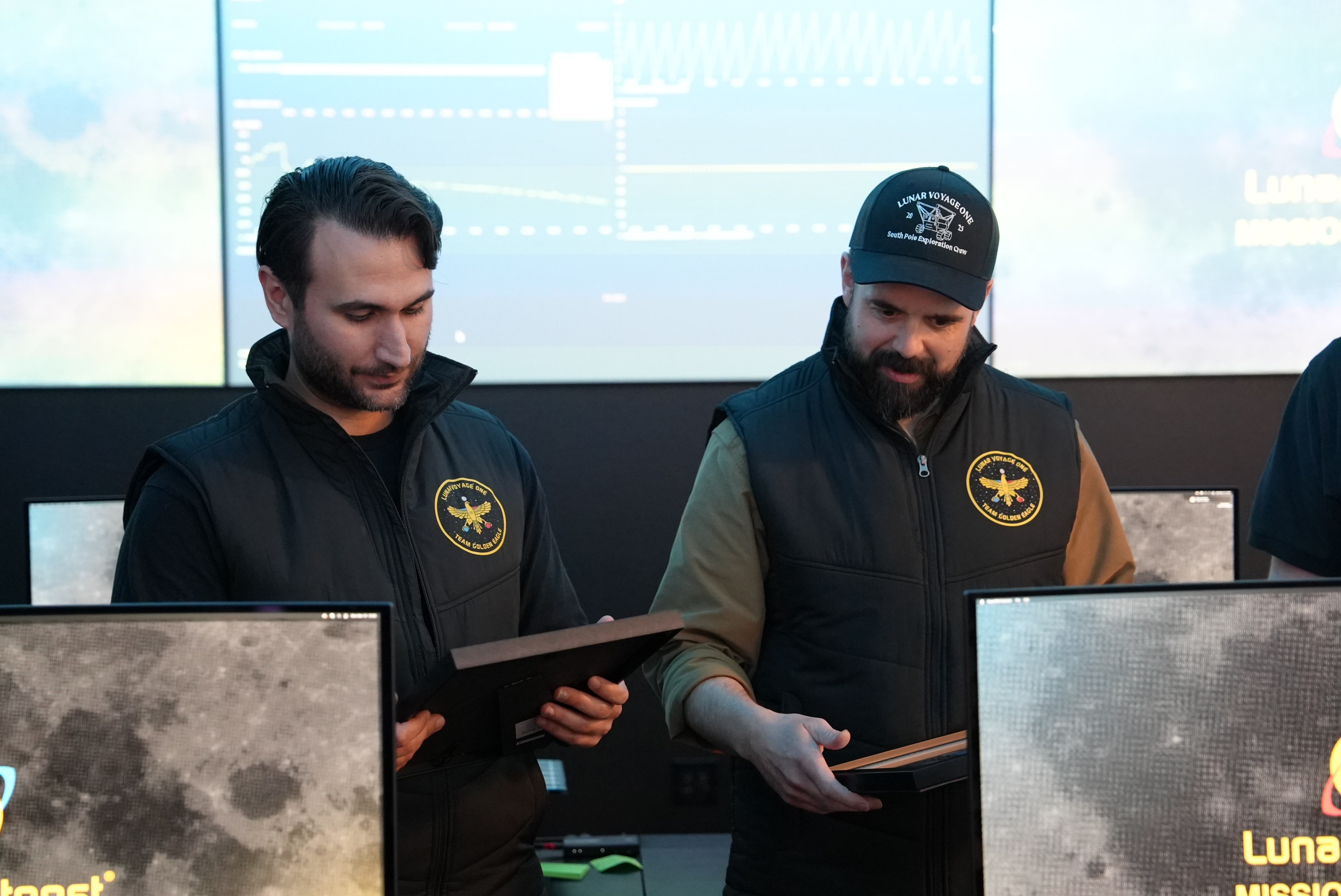 Justin Cyrus and a colleague reviewing material inside Lunar Outpost mission control
