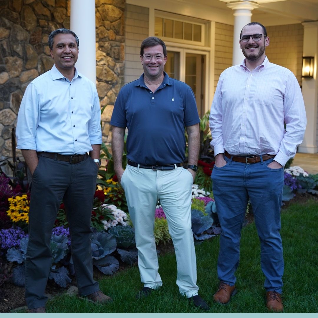 Justin Hillenbrand, at center, standing outdoors with two other people