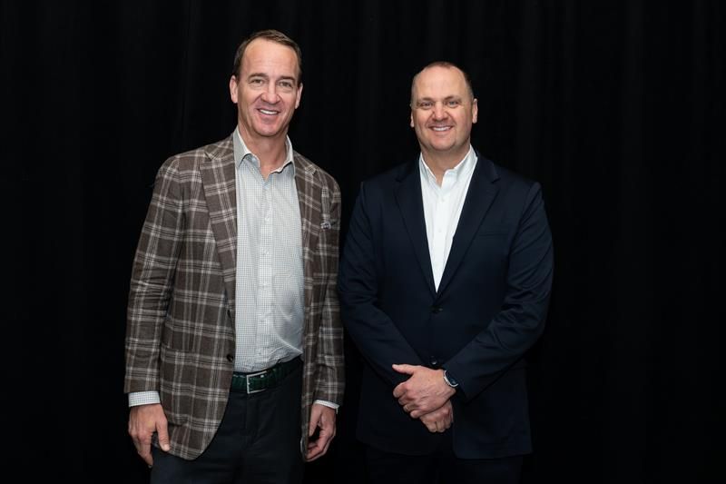 Peyton Manning, left, standing beside Justin Jude