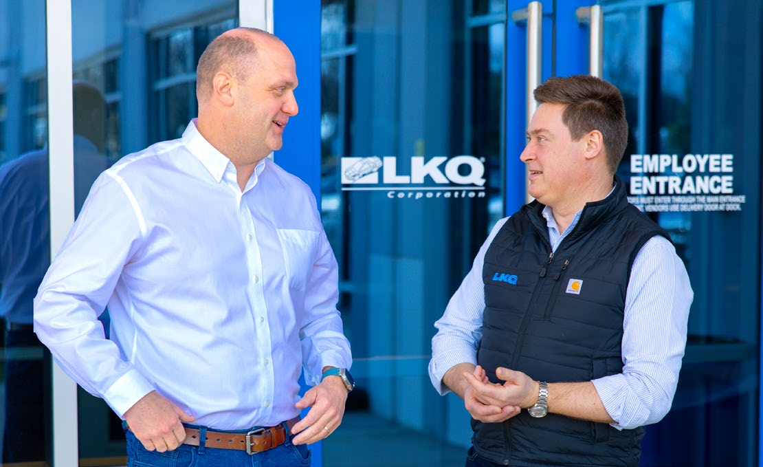 Justin Jude, left, talking with a colleague outside an LKQ entrance