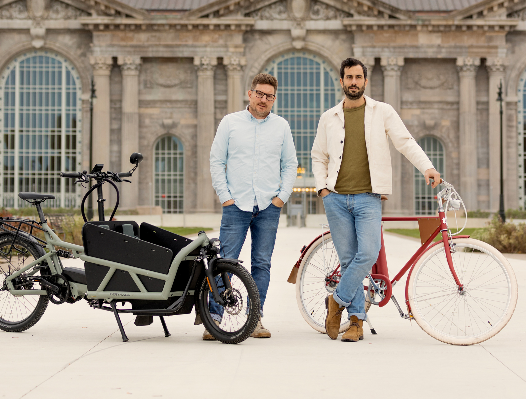 Chris Nolte and Justin Kosmides standing with electric bicycles outside Michigan Central in Detroit