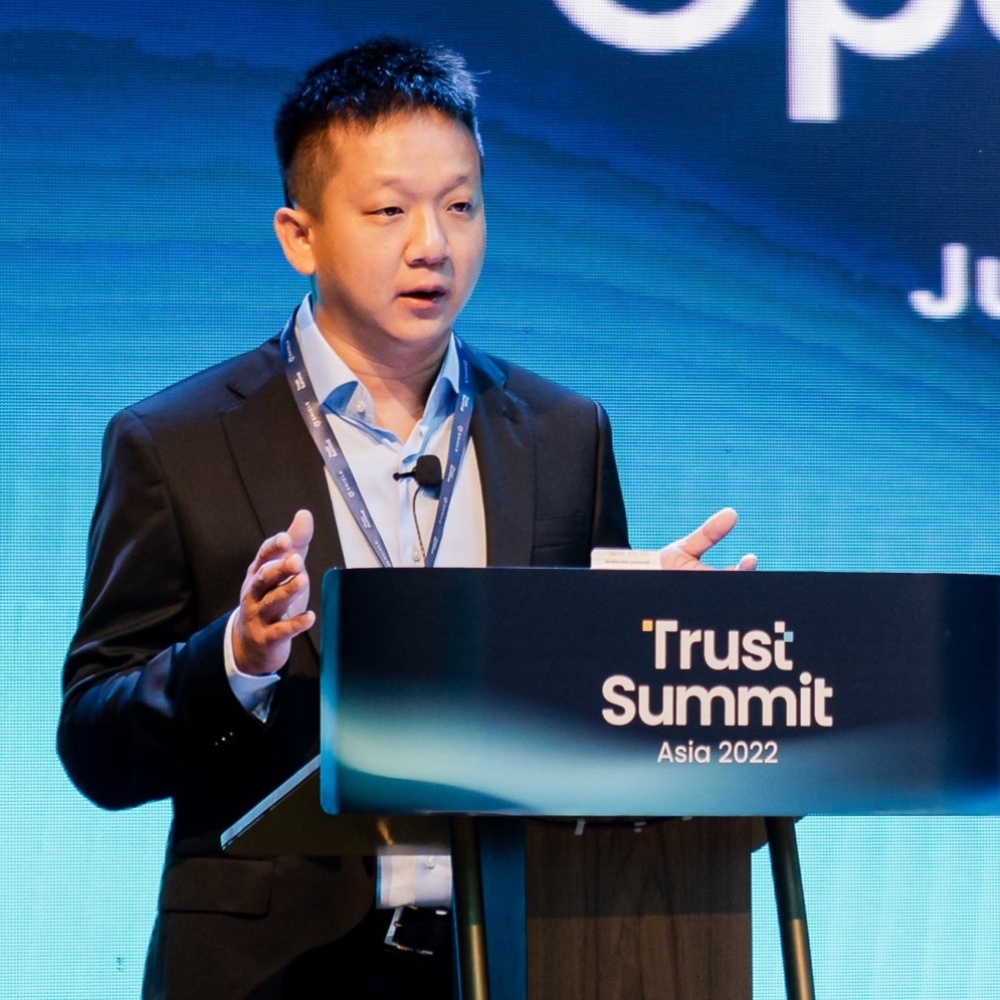 Justin Lie speaking behind the Trust Summit Asia 2022 lectern