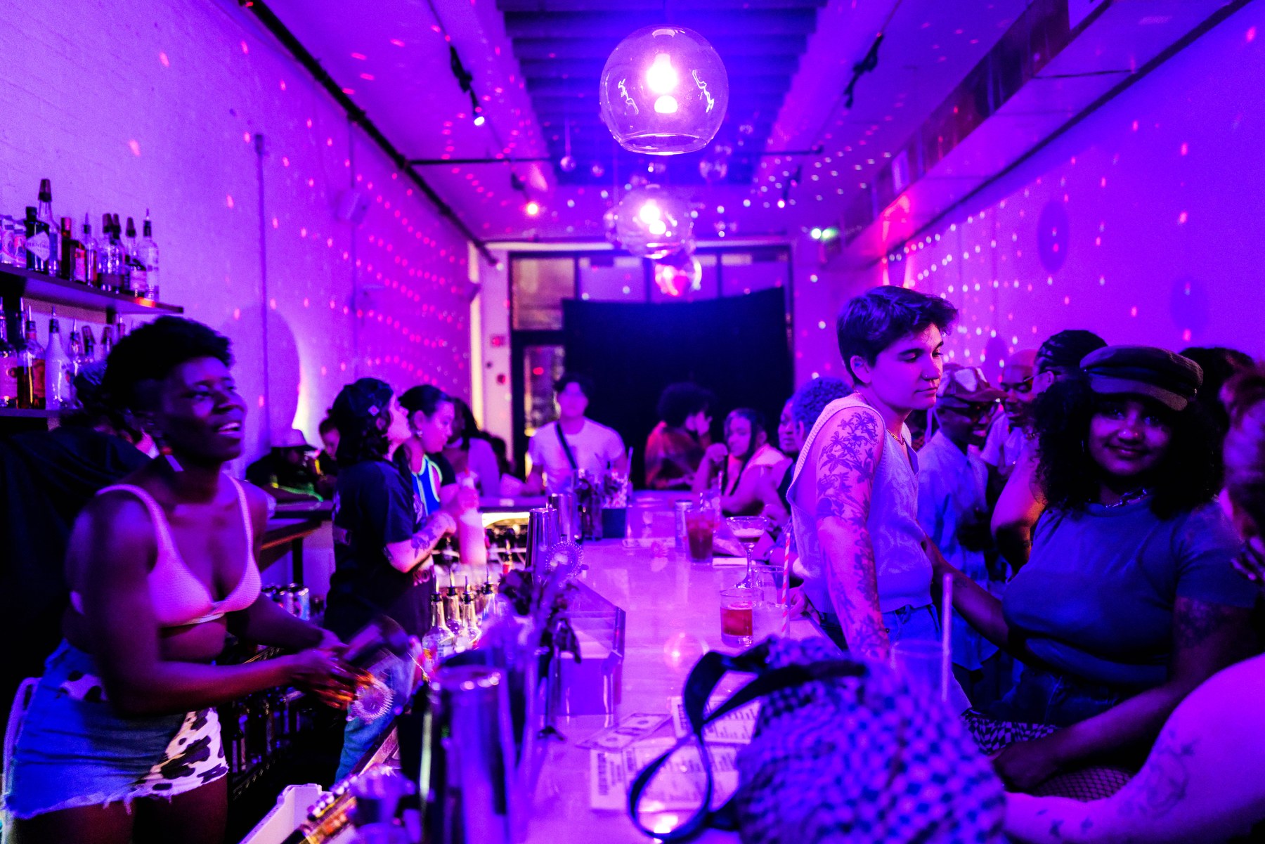 A crowd dancing under purple lights inside The Bush