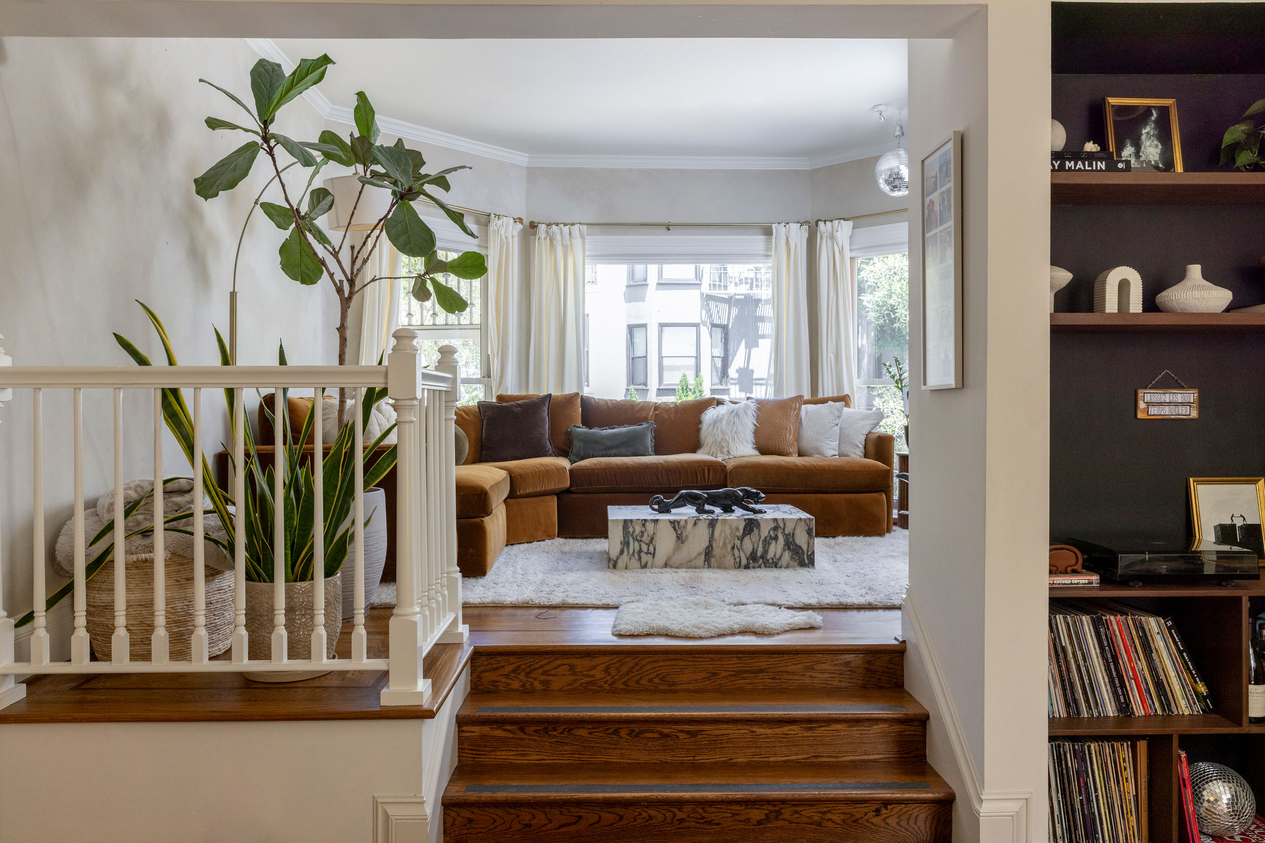 Palefsky’s sunlit living room, with a brown sofa, plants, records and a marble coffee table