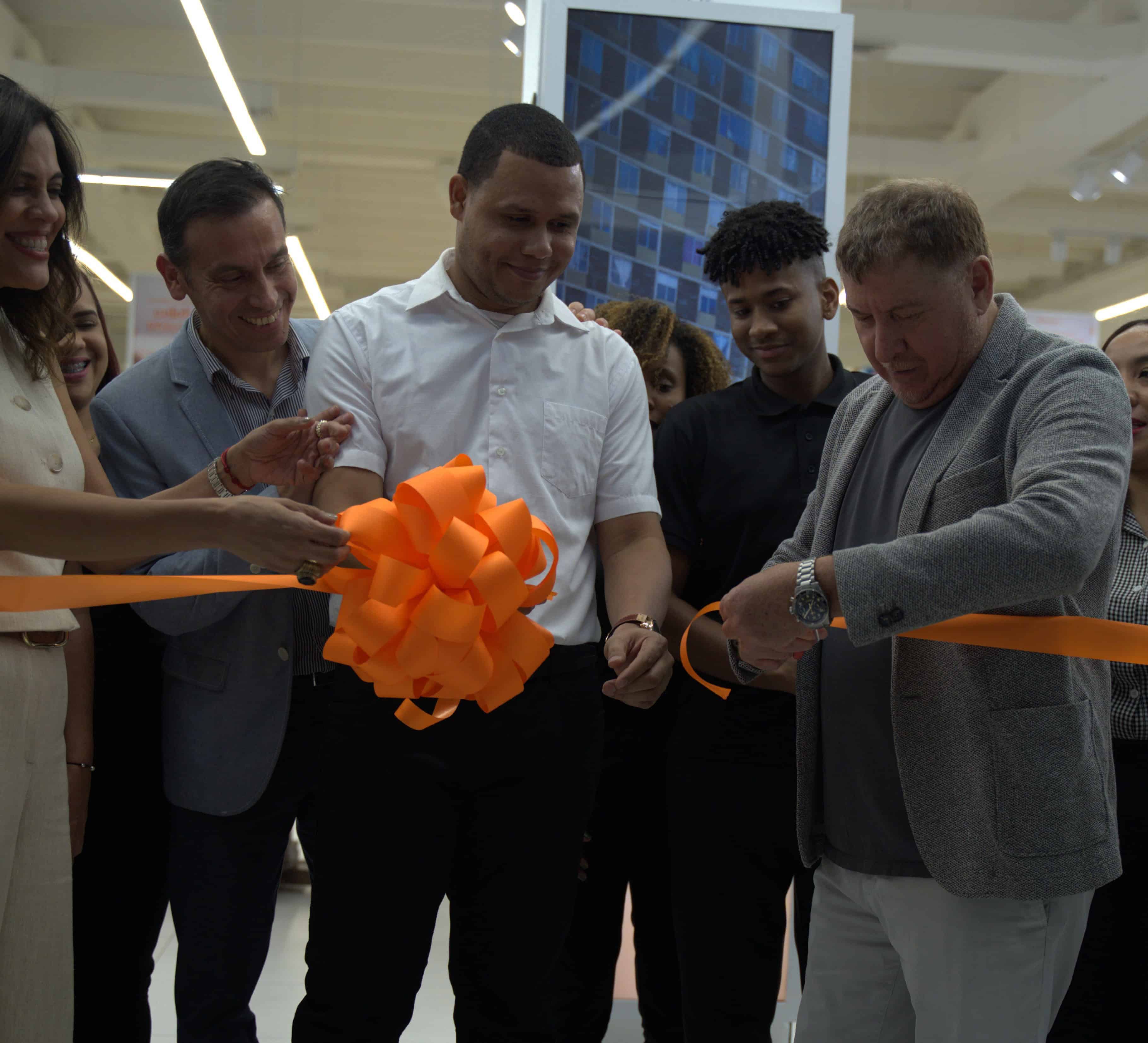 Justo Fuentes, at right, cuts an orange ribbon alongside Payless colleagues at the Megacentro reopening.