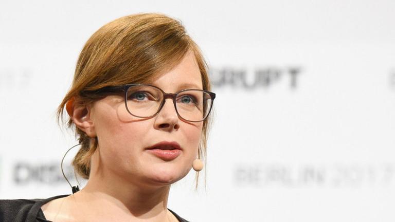 Jutta Steiner speaking with a headset microphone at an event