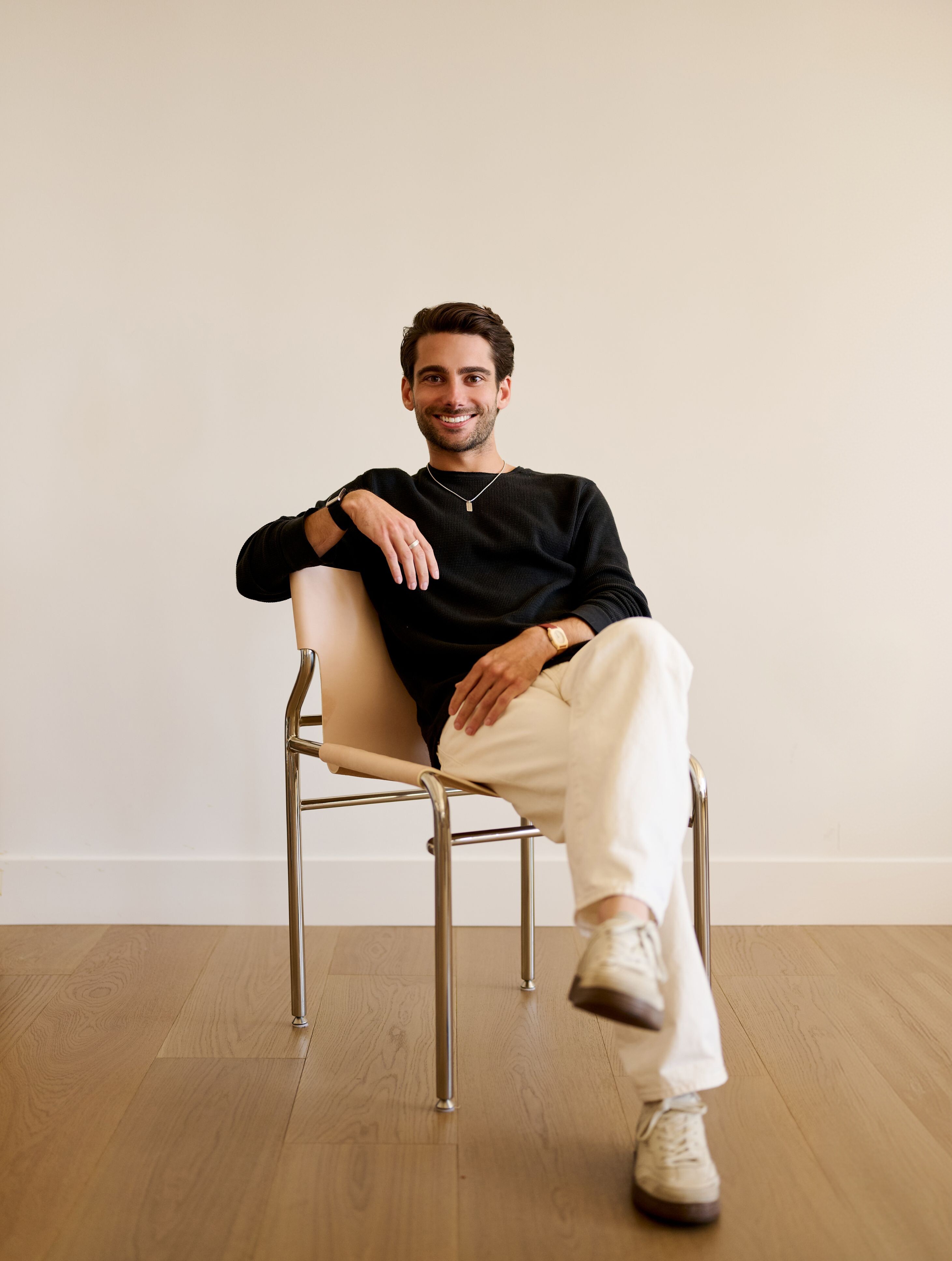 Kahlil Lalji seated in a chair, smiling at the camera