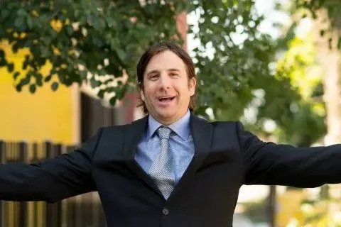 Kale Realty founder Nick Patterson outdoors with his arms outstretched