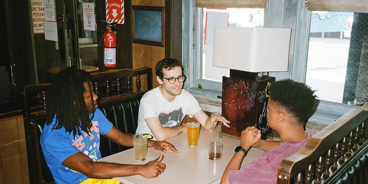 The three No Such Thing hosts talking around a table