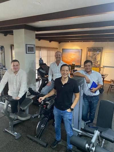 Kamal Mahyuddin, at right, standing with three colleagues in a room with exercise equipment