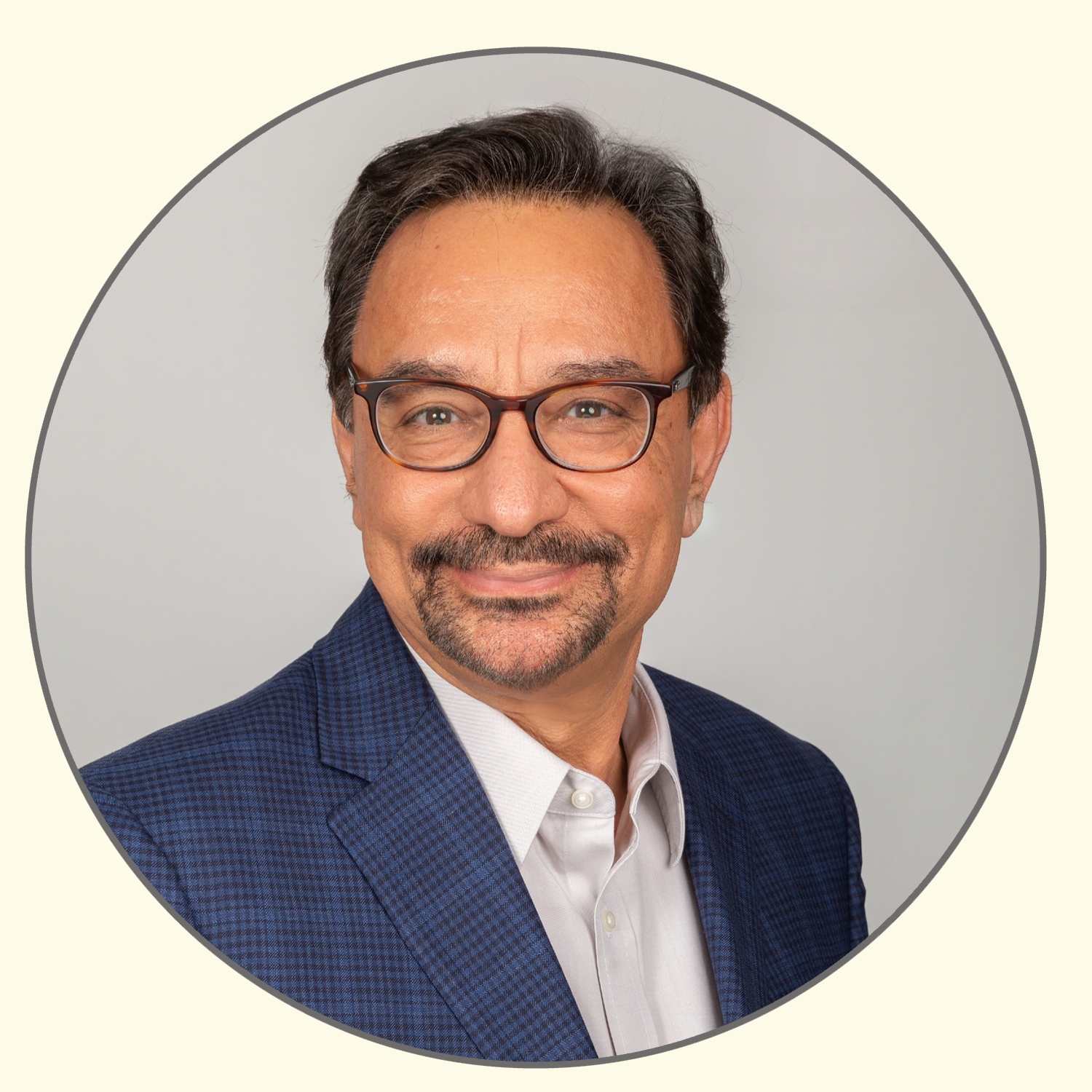 An alternate R3 Vascular company photograph of Kamal Ramzipoor wearing glasses and a blue jacket