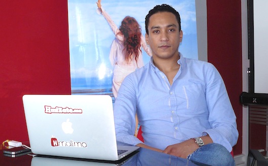 Kamal Reggad seated beside his laptop at the Hmizate and Hmall office