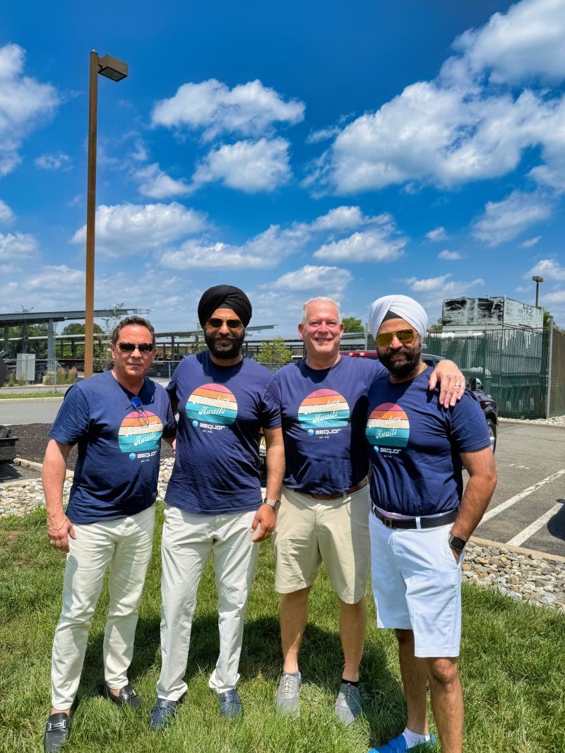 Four Aequor executives, including co-CEOs Kamal and Manmeet Virdi, outdoors in matching navy T-shirts